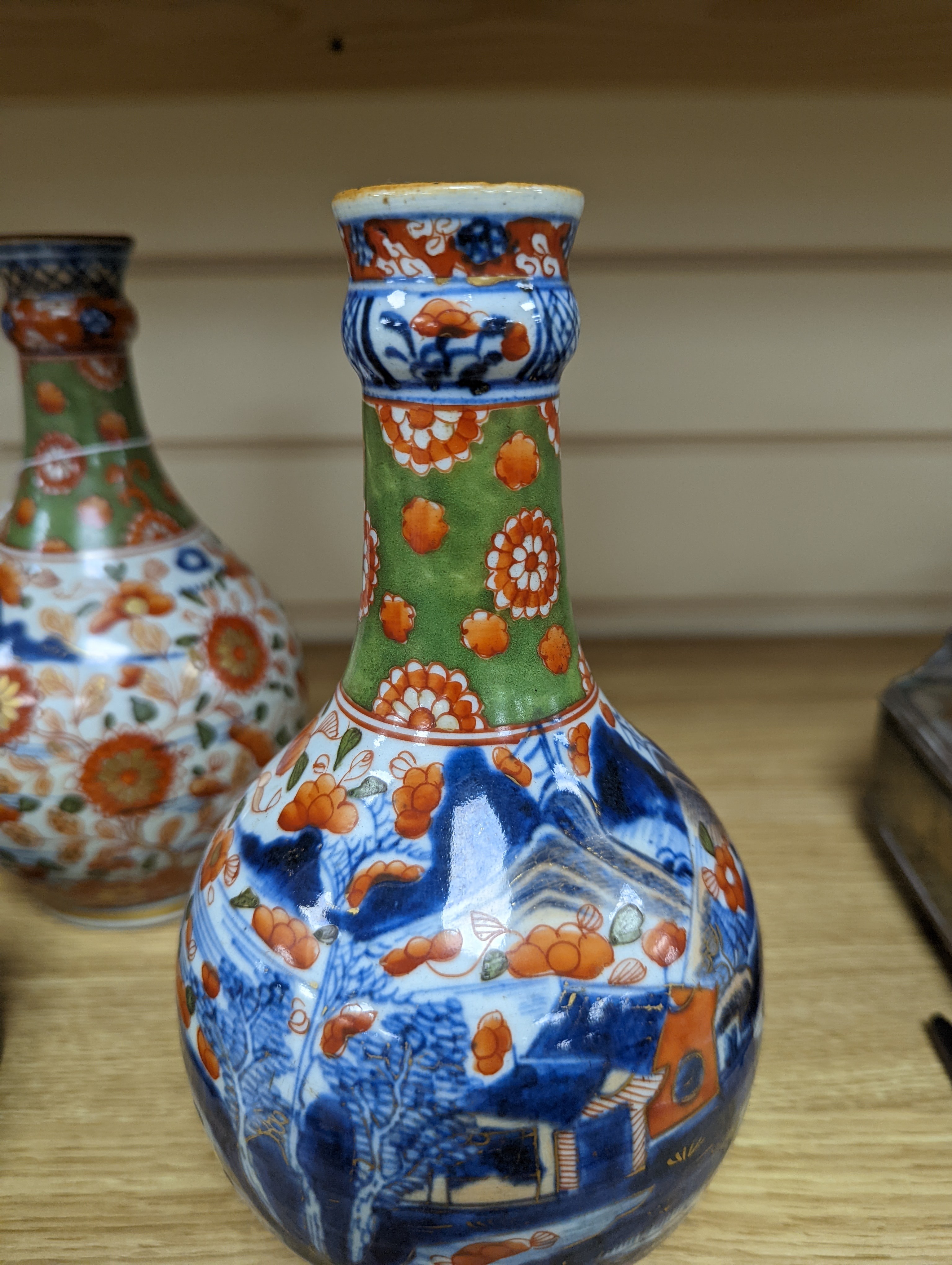 A pair of 18th century Chinese clobbered blue and white bottle vases 23cm